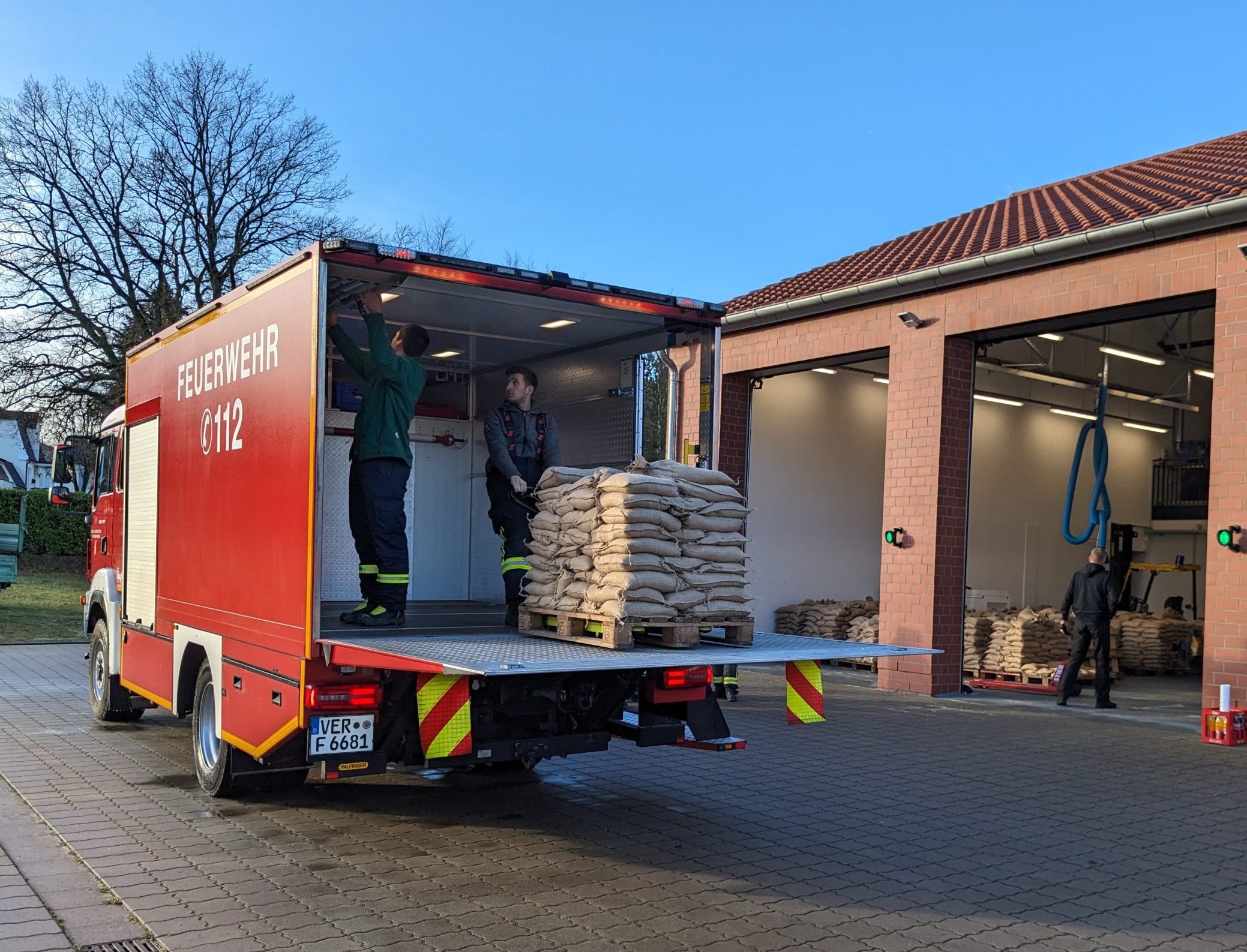 Feuerwehrleute beladen ein Feuerwehrfahrzeug